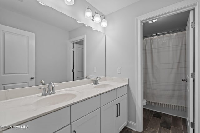 1035 Bent Blade Ln, Wilmington, NC 28411 - bathroom featuring double vanity, wood tiled floors, and a shower with shower curtain