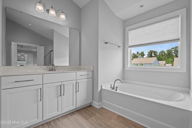 1035 Bent Blade Ln, Wilmington, NC 28411 - full bathroom featuring vanity, a bath, lofted ceiling, and wood finished floors