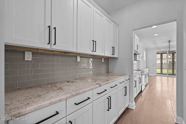 1035 Bent Blade Ln, Wilmington, NC 28411 - kitchen featuring white cabinetry, backsplash, light wood-style floors, light stone counters, and recessed lighting