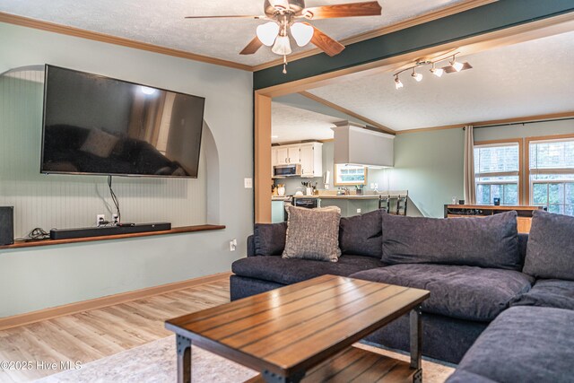 1360 Rays Bridge Rd, Whispering Pines, NC 28327 - living room with wood finished floors, ceiling fan, vaulted ceiling, a textured ceiling, and crown molding