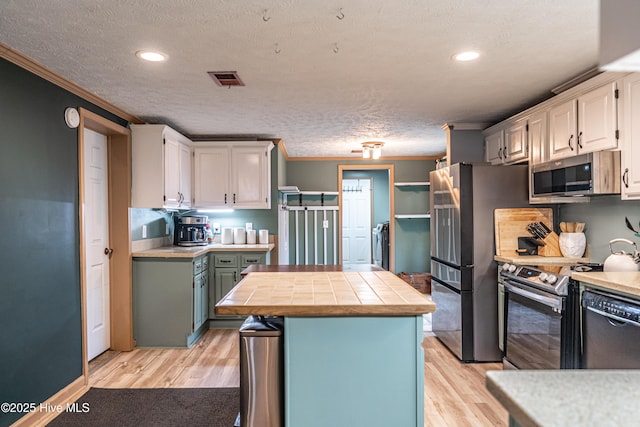 1360 Rays Bridge Rd, Whispering Pines, NC 28327 - kitchen featuring appliances with stainless steel finishes, ornamental molding, a textured ceiling, light wood finished floors, and recessed lighting