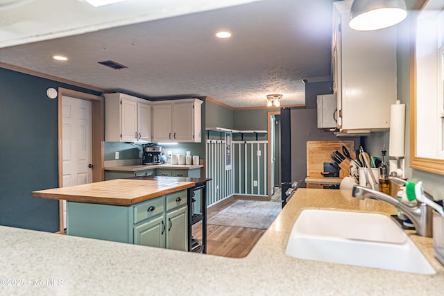 1360 Rays Bridge Rd, Whispering Pines, NC 28327 - kitchen with butcher block countertops, crown molding, light wood-type flooring, recessed lighting, and white cabinetry