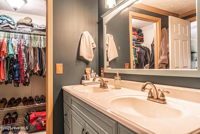 1360 Rays Bridge Rd, Whispering Pines, NC 28327 - bathroom featuring a textured ceiling, ornamental molding, double vanity, and a walk in closet