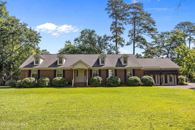 1909 Pawnee Dr, Kinston, NC 28504 - cape cod-style house featuring a front lawn and brick siding