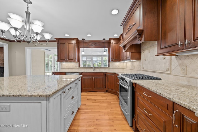 1909 Pawnee Dr, Kinston, NC 28504 - kitchen with stainless steel gas range, recessed lighting, light wood-style floors, light stone counters, and a chandelier