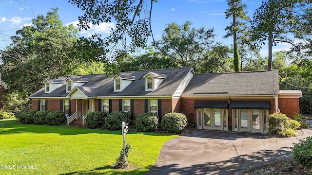 1909 Pawnee Dr, Kinston, NC 28504 - cape cod-style house with french doors, brick siding, a front lawn, and concrete driveway
