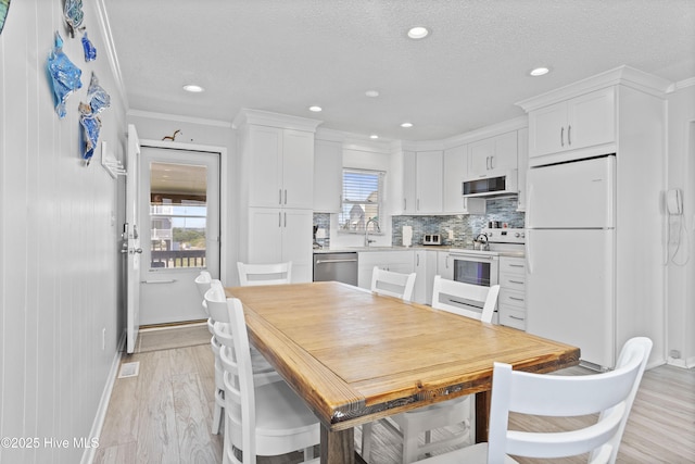 2101 Ocean Dr Unit A, Emerald Isle, NC 28594 - dining room with light wood-style floors, crown molding, recessed lighting, and a textured ceiling