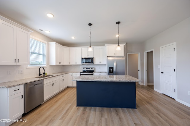 6001 Farmwood Loop, Wilson, NC 27896 - kitchen featuring appliances with stainless steel finishes, a center island, white cabinetry, light wood-style floors, and pendant lighting