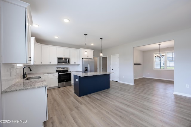 6001 Farmwood Loop, Wilson, NC 27896 - kitchen featuring stainless steel appliances, a center island, light wood-style floors, a chandelier, and white cabinets