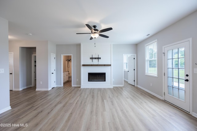 6001 Farmwood Loop, Wilson, NC 27896 - unfurnished living room with a ceiling fan, light wood finished floors, and a large fireplace