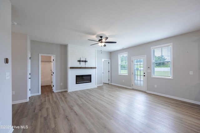 6001 Farmwood Loop, Wilson, NC 27896 - unfurnished living room with a ceiling fan, a large fireplace, and light wood finished floors
