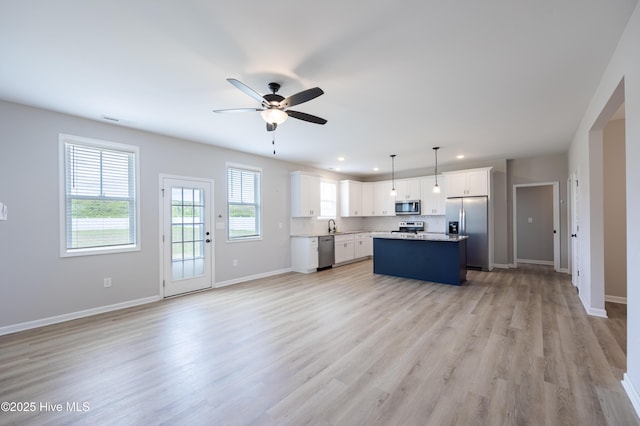 6001 Farmwood Loop, Wilson, NC 27896 - kitchen featuring stainless steel appliances, a kitchen island, open floor plan, a ceiling fan, and white cabinetry