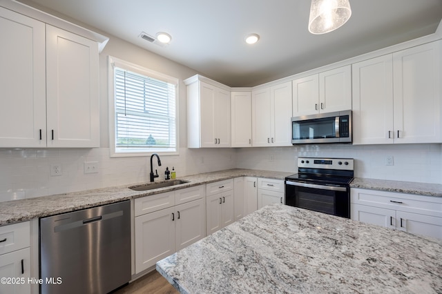 6001 Farmwood Loop, Wilson, NC 27896 - kitchen featuring appliances with stainless steel finishes, white cabinetry, and tasteful backsplash
