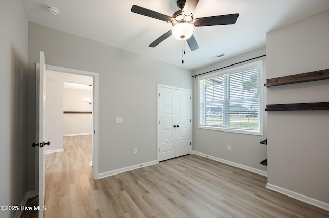 6001 Farmwood Loop, Wilson, NC 27896 - unfurnished bedroom with light wood finished floors and a ceiling fan