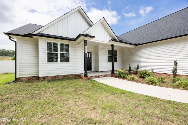 6001 Farmwood Loop, Wilson, NC 27896 - modern inspired farmhouse featuring board and batten siding, a porch, a front yard, and a shingled roof