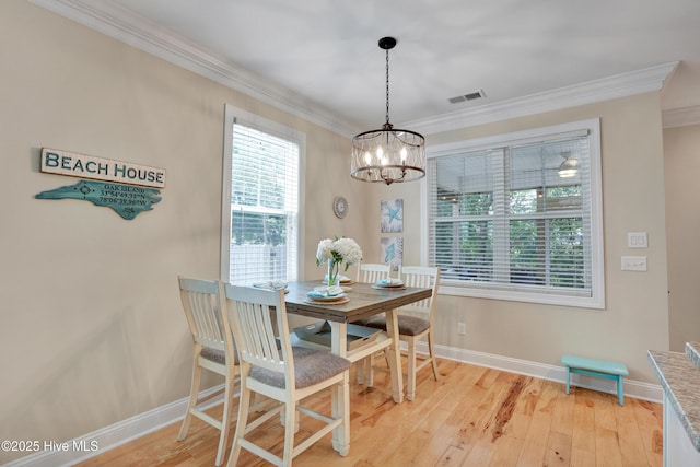 215 NE 54th St, Oak Island, NC 28465 - dining room with crown molding, a chandelier, and light wood-type flooring