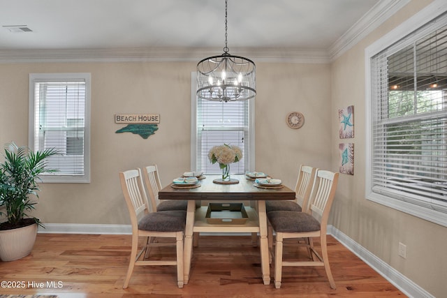 215 NE 54th St, Oak Island, NC 28465 - dining space with a chandelier, light wood-style floors, and crown molding