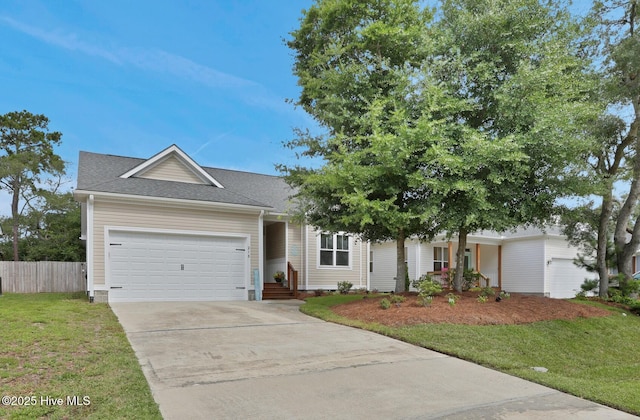 215 NE 54th St, Oak Island, NC 28465 - view of front of house featuring a garage, concrete driveway, and a shingled roof