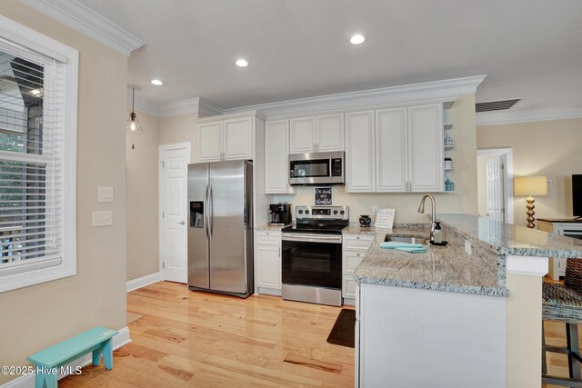 215 NE 54th St, Oak Island, NC 28465 - kitchen with appliances with stainless steel finishes, a peninsula, ornamental molding, open shelves, and white cabinetry