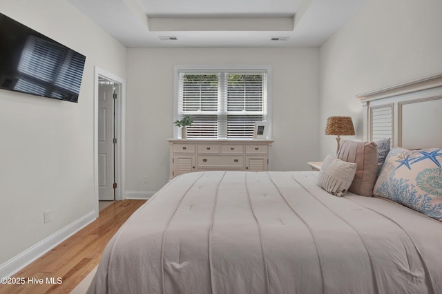 215 NE 54th St, Oak Island, NC 28465 - bedroom featuring light wood finished floors and a tray ceiling