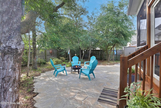 215 NE 54th St, Oak Island, NC 28465 - fenced backyard featuring a fire pit and a patio