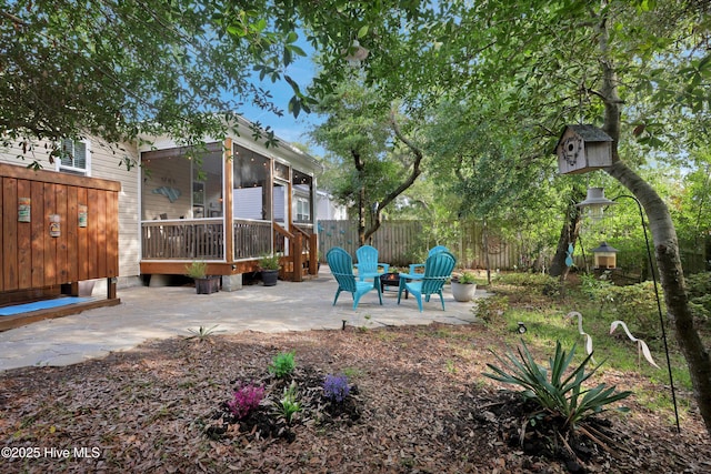 215 NE 54th St, Oak Island, NC 28465 - view of yard featuring a patio, a sunroom, and an outdoor fire pit