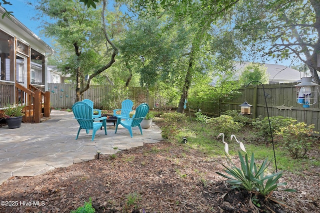 215 NE 54th St, Oak Island, NC 28465 - fenced backyard with a patio area, a sunroom, and a fire pit