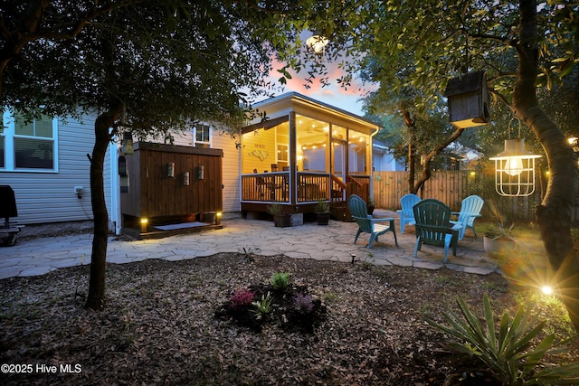 215 NE 54th St, Oak Island, NC 28465 - back of house at dusk featuring a patio area and a deck