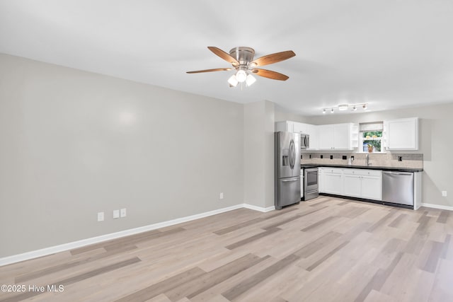 1004 S 8th St, Wilmington, NC 28401 - kitchen featuring appliances with stainless steel finishes, decorative backsplash, ceiling fan, white cabinetry, and light wood-type flooring