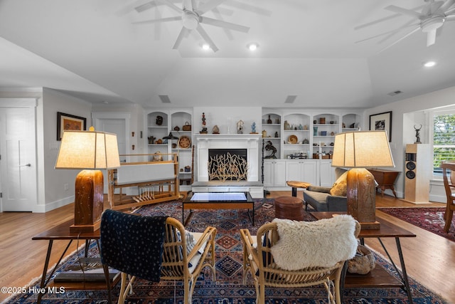 110 Mariners Ct, New Bern, NC 28562 - living room featuring ceiling fan, light wood-style floors, vaulted ceiling, built in features, and a fireplace with raised hearth
