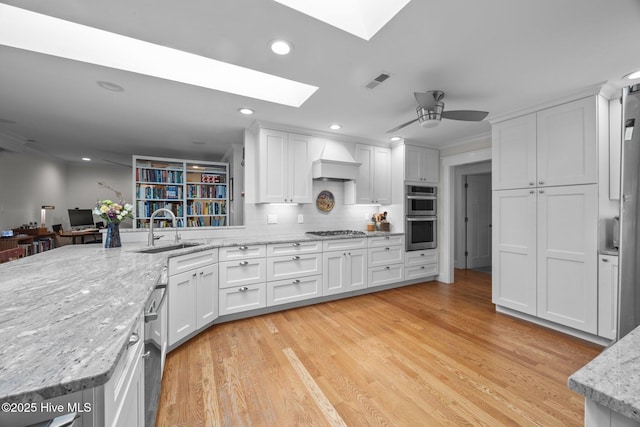 110 Mariners Ct, New Bern, NC 28562 - kitchen featuring a skylight, appliances with stainless steel finishes, white cabinets, a ceiling fan, and recessed lighting