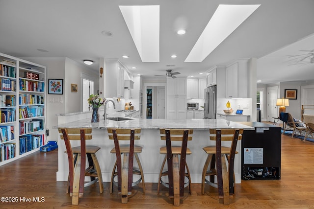 110 Mariners Ct, New Bern, NC 28562 - kitchen with high quality fridge, ceiling fan, a skylight, light stone counters, and recessed lighting
