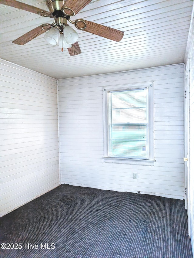 1333 Weldon Ave, Rocky Mount, NC 27804 - empty room featuring dark carpet, wooden ceiling, wood walls, and ceiling fan