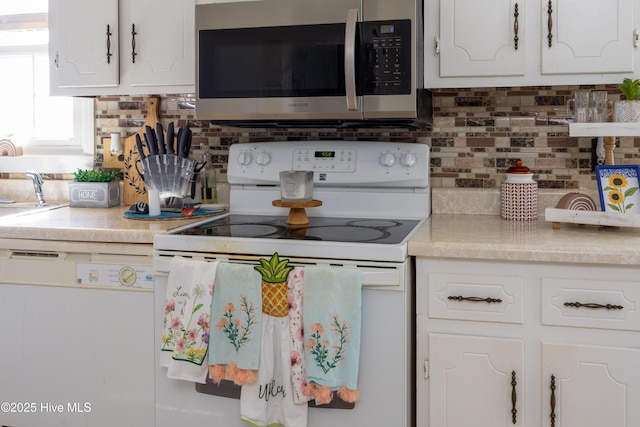 800 S Vance St, Fremont, NC 27830 - kitchen with white electric stove, stainless steel microwave, tasteful backsplash, and white cabinets