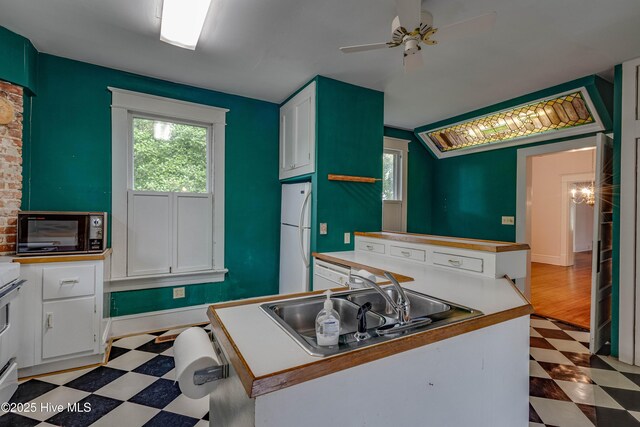 1305 N Market St, Washington, NC 27889 - kitchen featuring light floors, freestanding refrigerator, ceiling fan, white cabinetry, and black microwave