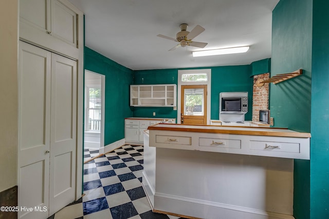 1305 N Market St, Washington, NC 27889 - kitchen with dark flooring, a ceiling fan, white cabinetry, and a peninsula