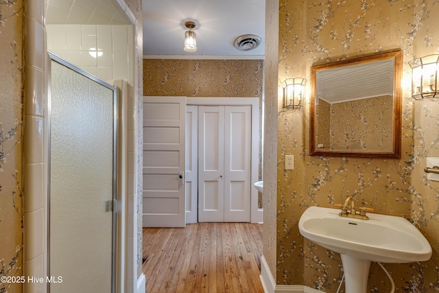 1305 N Market St, Washington, NC 27889 - full bath with hardwood / wood-style flooring, a shower stall, and wallpapered walls
