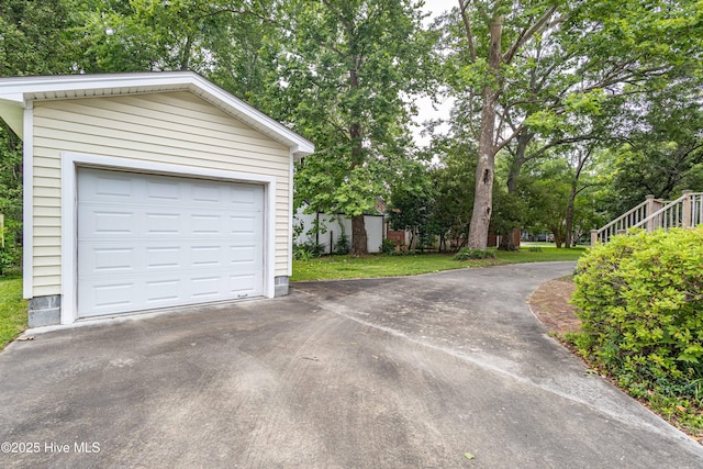 1305 N Market St, Washington, NC 27889 - detached garage featuring asphalt driveway and view of wooded area