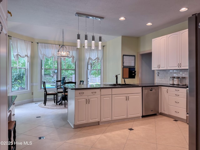 4109 Devonshire Ln, Wilmington, NC 28409 - kitchen featuring stainless steel dishwasher, a peninsula, white cabinetry, hanging light fixtures, and decorative backsplash