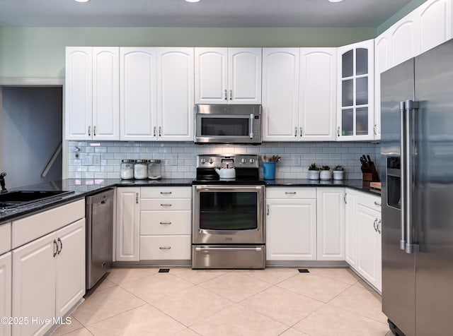 4109 Devonshire Ln, Wilmington, NC 28409 - kitchen with appliances with stainless steel finishes, glass insert cabinets, white cabinetry, decorative backsplash, and recessed lighting