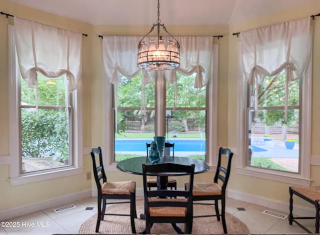 4109 Devonshire Ln, Wilmington, NC 28409 - dining room featuring a chandelier, plenty of natural light, light tile patterned floors, and vaulted ceiling
