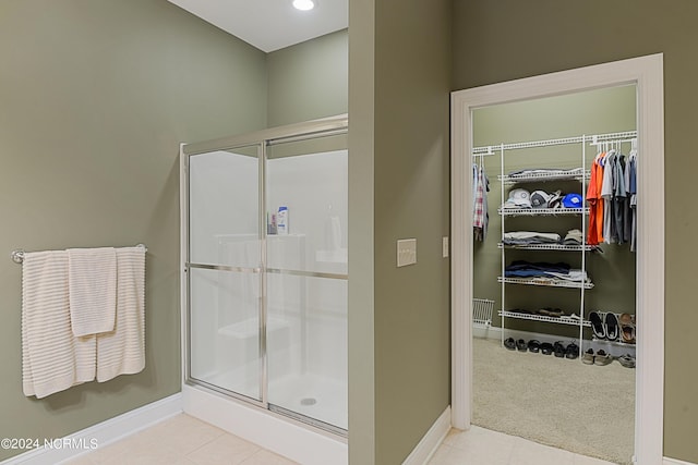 8975 Smithfield Dr NW Apt 2, Calabash, NC 28467 - bathroom featuring a stall shower, a spacious closet, and tile patterned flooring
