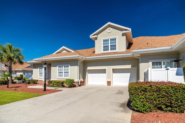 8975 Smithfield Dr NW Apt 2, Calabash, NC 28467 - view of front facade with stucco siding, driveway, a garage, and roof with shingles