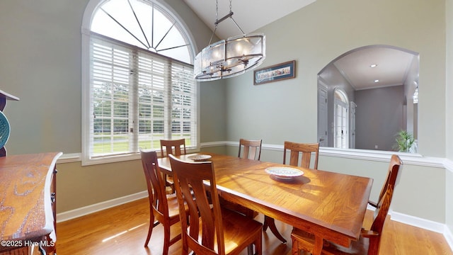 104 Chatham Pass, Trent Woods, NC 28562 - dining space with arched walkways, light wood-type flooring, a chandelier, and lofted ceiling
