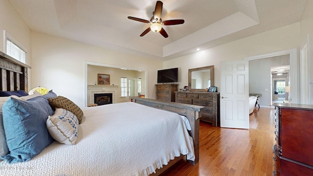 104 Chatham Pass, Trent Woods, NC 28562 - bedroom featuring a fireplace, a raised ceiling, wood finished floors, and ceiling fan