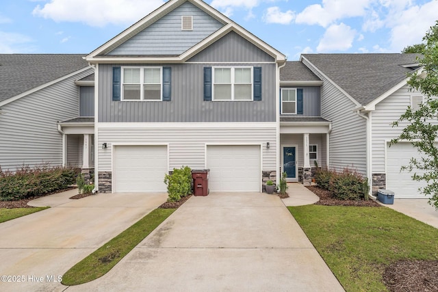 1571 Grey Cliff Run, Wilmington, NC 28405 - view of front facade with stone siding, board and batten siding, concrete driveway, and a garage