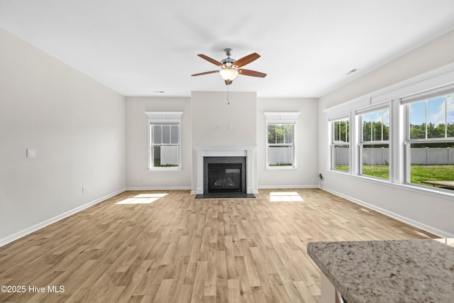 132 Mill Run, South Mills, NC 27976 - unfurnished living room with light wood-type flooring, a ceiling fan, plenty of natural light, and a fireplace with flush hearth