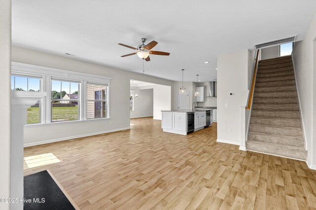 132 Mill Run, South Mills, NC 27976 - unfurnished living room with light wood-style flooring, a ceiling fan, stairs, wine cooler, and recessed lighting