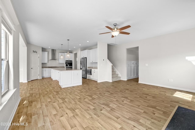 132 Mill Run, South Mills, NC 27976 - kitchen with stainless steel appliances, open floor plan, wall chimney range hood, light wood-type flooring, and a ceiling fan