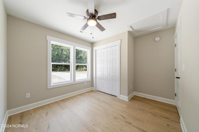72 S Greensboro Rd, Southport, NC 28461 - unfurnished bedroom with attic access, light wood-style flooring, a closet, and a ceiling fan